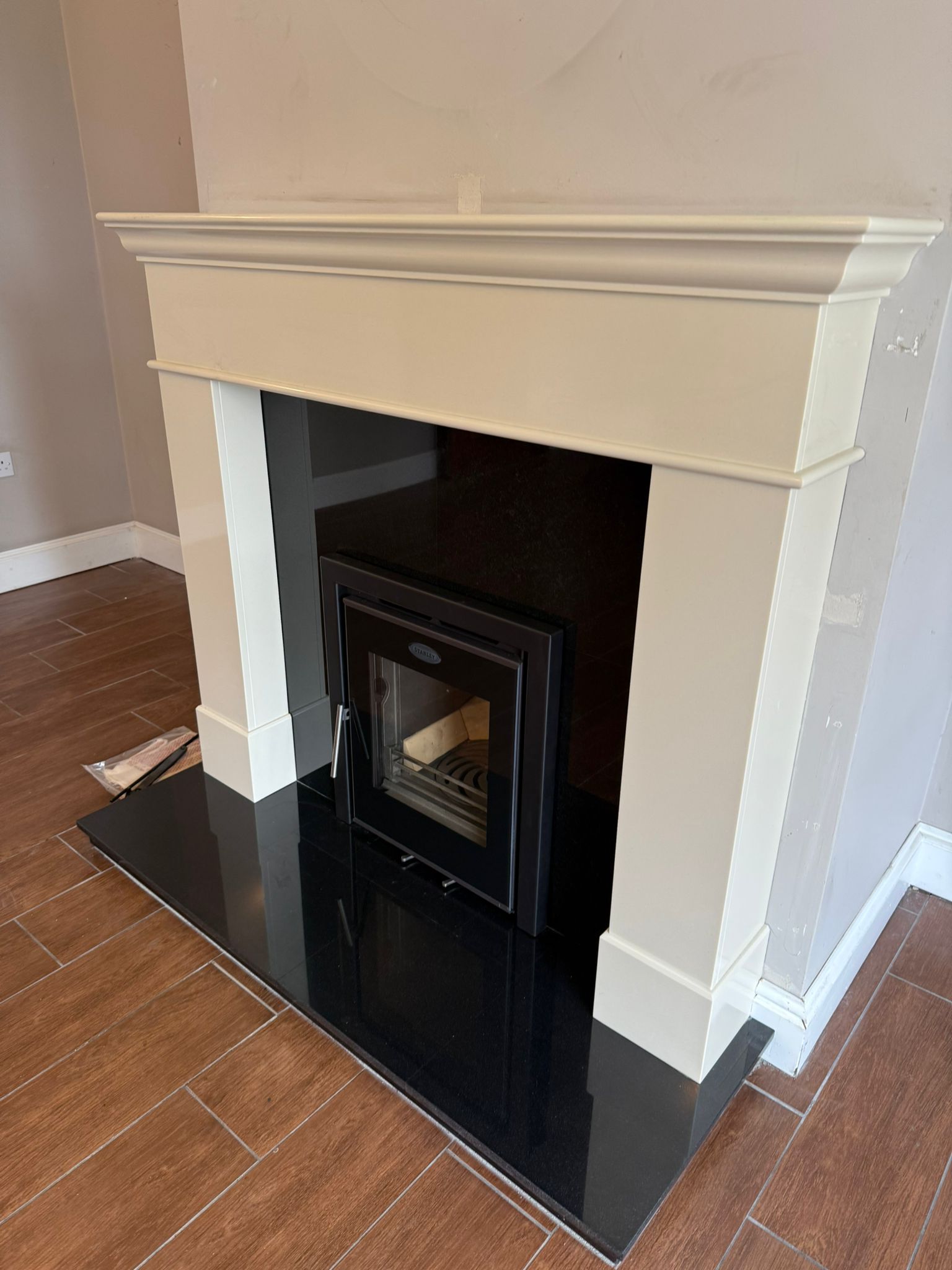 Stove installation finished on a tiled floor with cream surround
