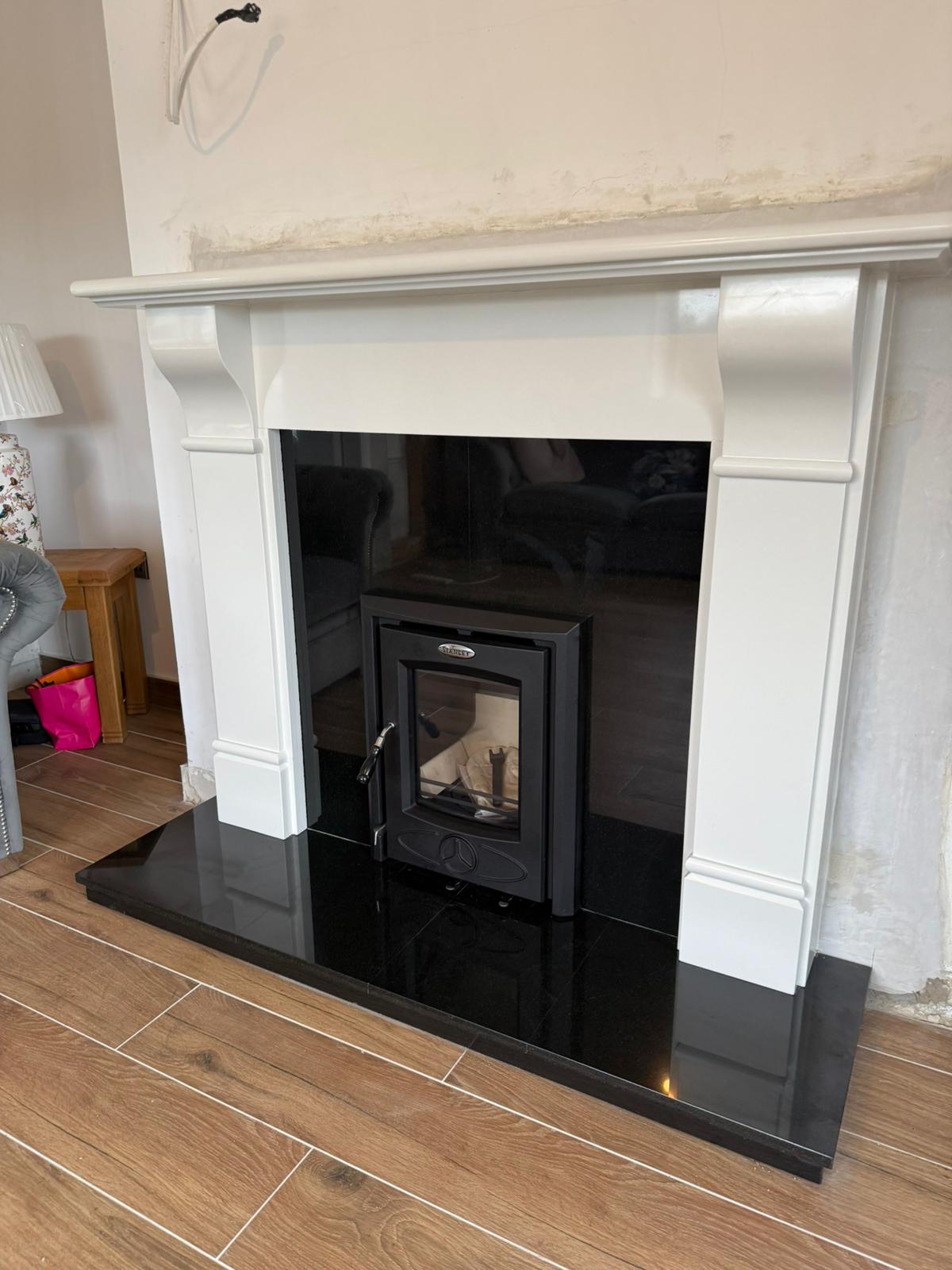 Stove installation in living room with grey sofa